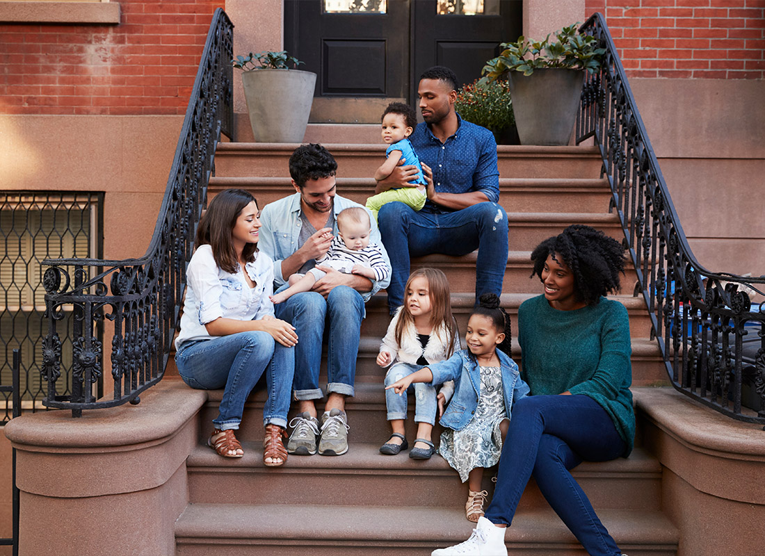 Insurance Solutions - Two Families With Kids Sitting on the Front Stoops of Their Apartment in New York City